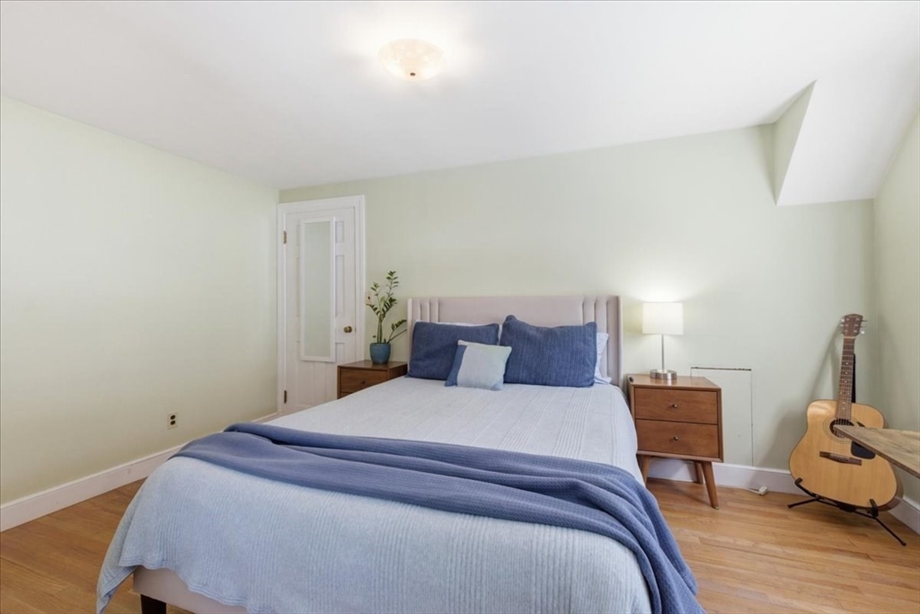 46 Park Street Dedham, MA 02026 - Photo 24 of 35 a bedroom with a bed a mirror and wooden floor