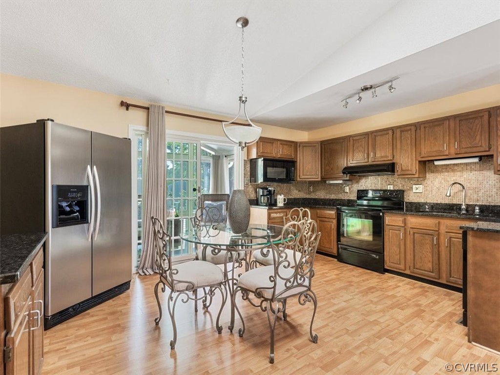 6601 Brambleton Road Chesterfield, VA 23832 - Photo 9 of 34 a kitchen with stainless steel appliances granite countertop a refrigerator a stove top oven a sink dishwasher a dining table and chairs with wooden floor