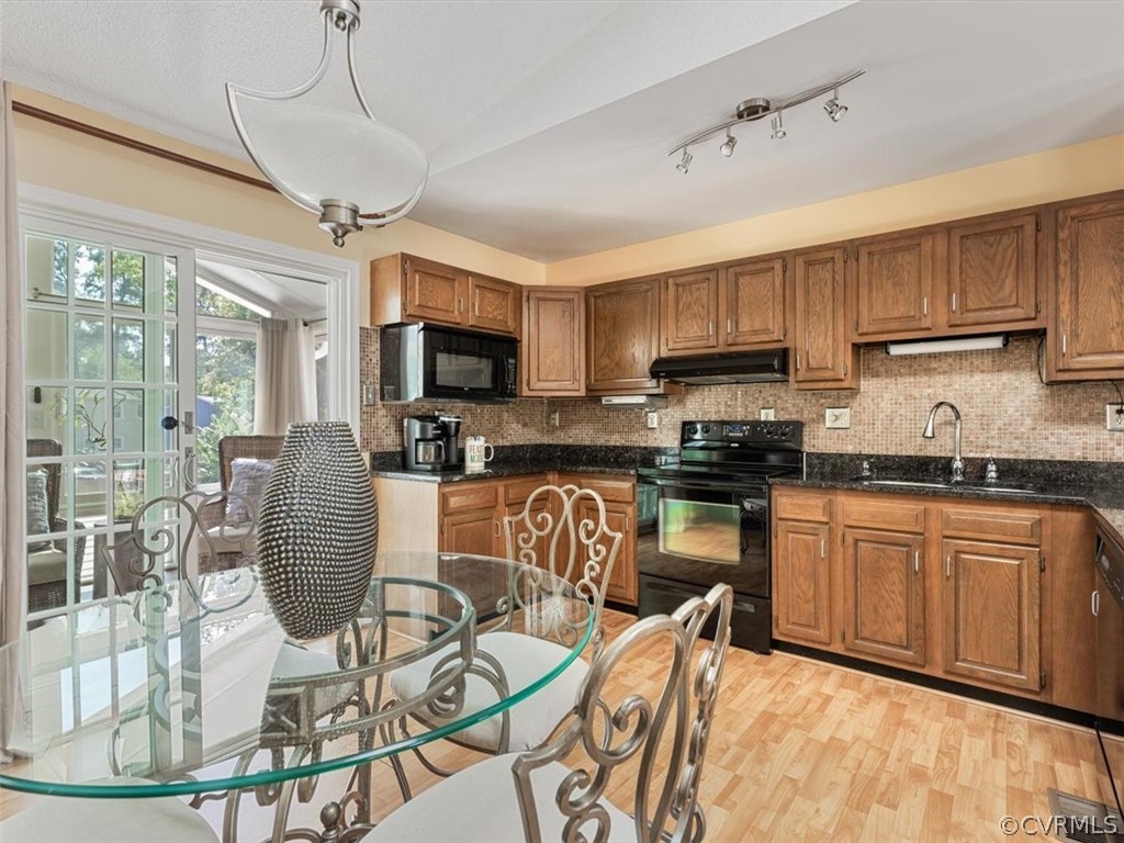6601 Brambleton Road Chesterfield, VA 23832 - Photo 10 of 34 a kitchen with stainless steel appliances granite countertop a stove top oven a sink a dining table and chairs