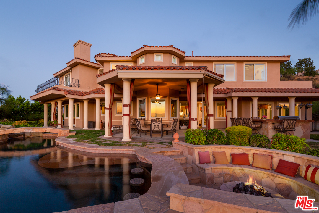 a front view of a house with swimming pool and furniture