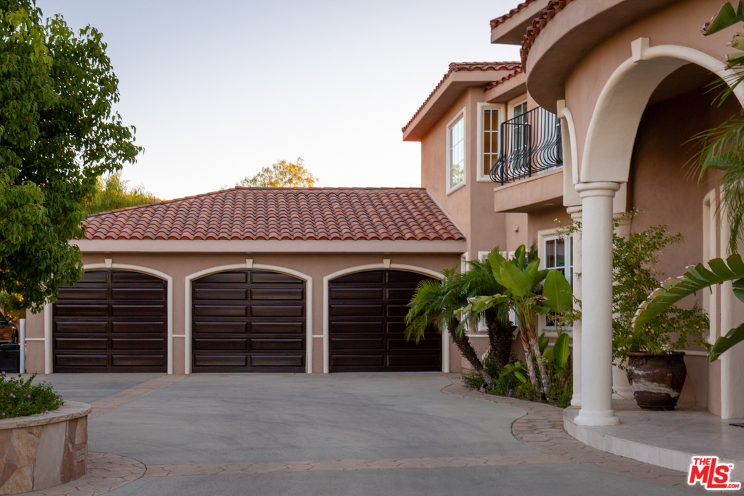 24533 Desert Avenue Newhall, CA 91321 - Photo 3 of 48 a view of a house with garage and plants
