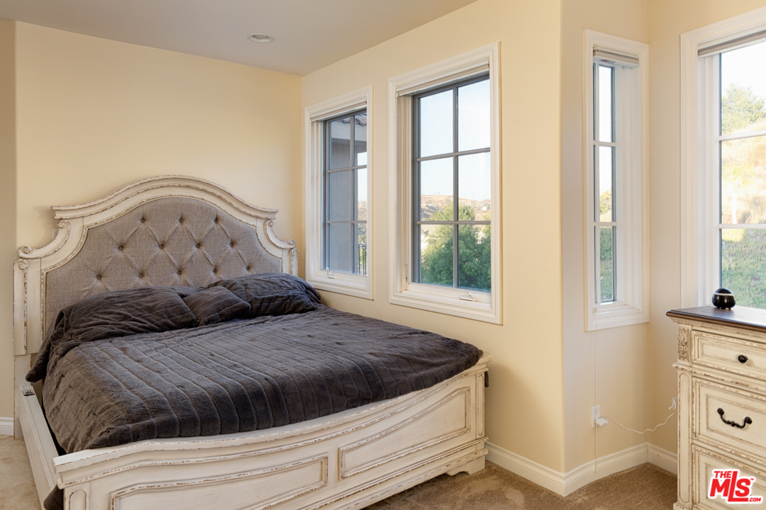 24533 Desert Avenue Newhall, CA 91321 - Photo 30 of 48 a large bed sitting in a bedroom next to a window