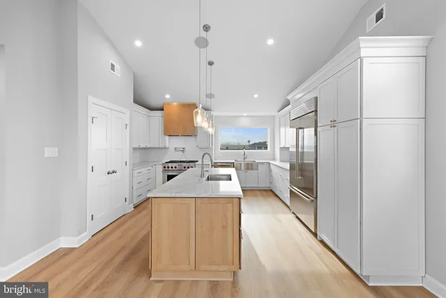 a kitchen with a sink stainless steel appliances and cabinets