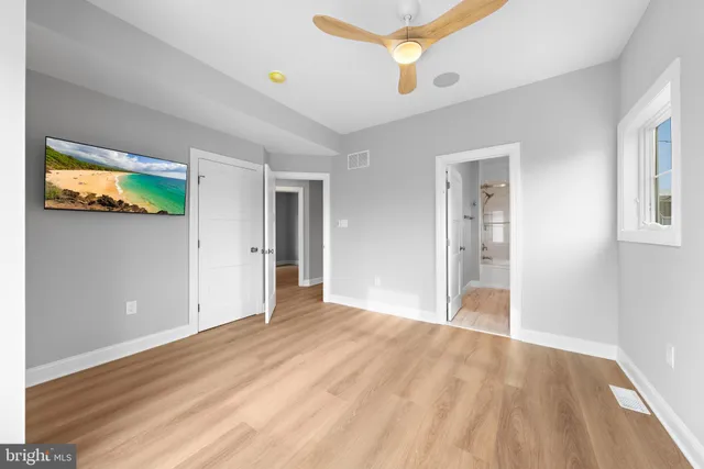 a view of an empty room with closet and a window