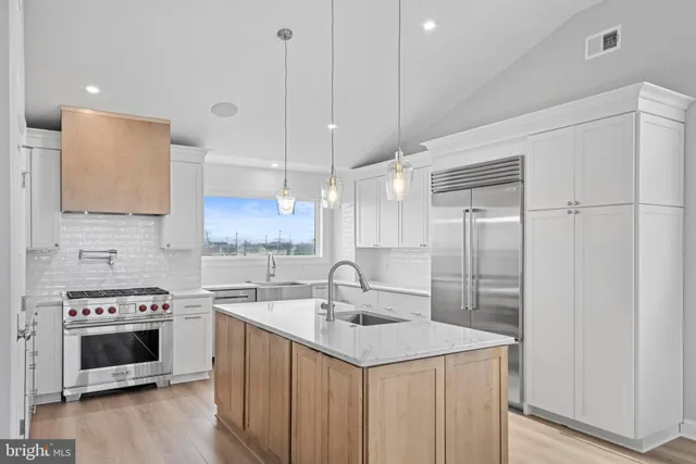 a kitchen with white cabinets and sink