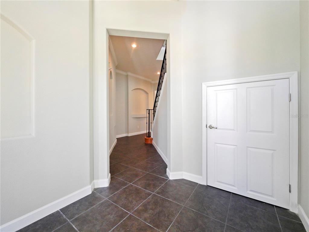 7710 Linkside Loop Reunion, FL 34747 - Photo 16 of 33 an entryway of a house with wooden floor and a hallway