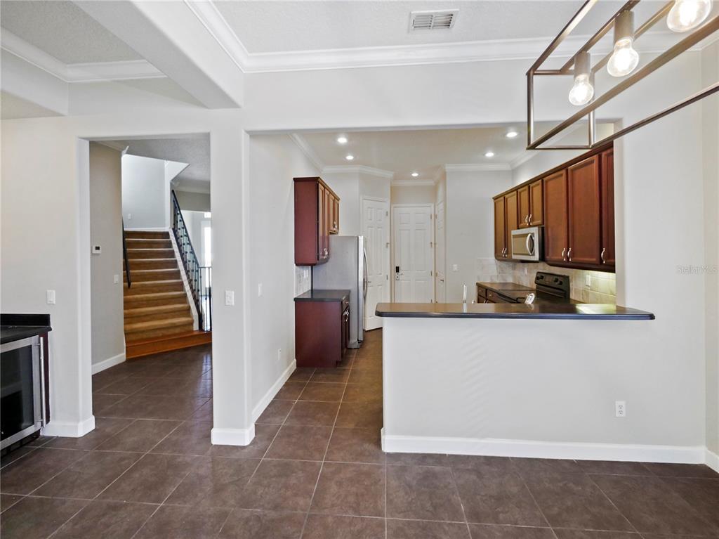 7710 Linkside Loop Reunion, FL 34747 - Photo 23 of 33 a living room with stainless steel appliances kitchen island granite countertop furniture a refrigerator and a stove