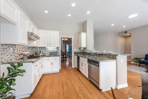 a large kitchen with stainless steel appliances granite countertop a stove a sink and a refrigerator