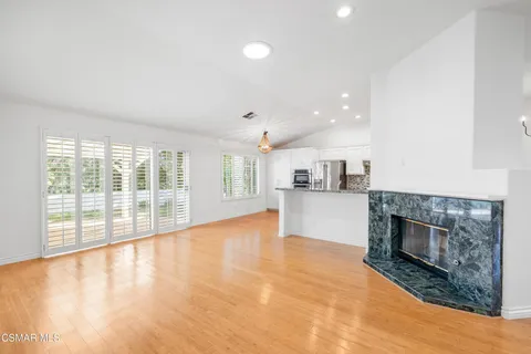 a view of empty room with wooden floor and fireplace