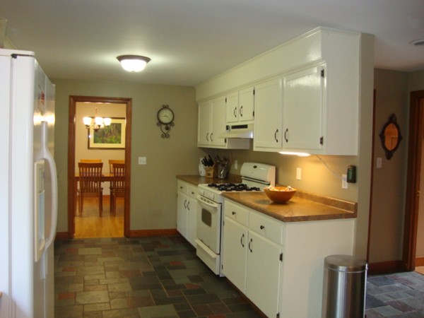 228 Braley Hill Road Rochester, MA 02770 - Photo 10 of 18 a kitchen with a stove and a refrigerator