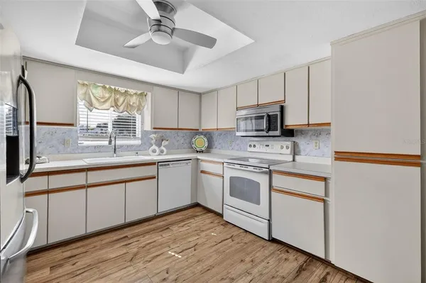 a kitchen with granite countertop a stove a sink and a microwave