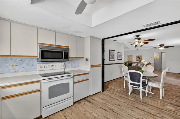 a kitchen with a dining table chairs appliances and cabinets