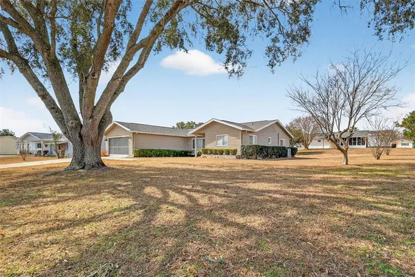 a front view of a house with a yard and large trees