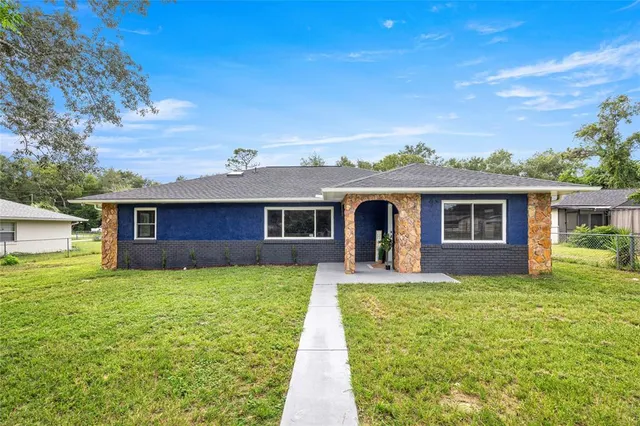 a front view of a house with a yard and trees