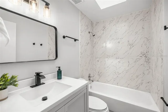 a bathroom with a sink a toilet and bathtub