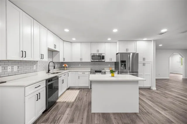 a kitchen with stainless steel appliances a refrigerator sink and cabinets