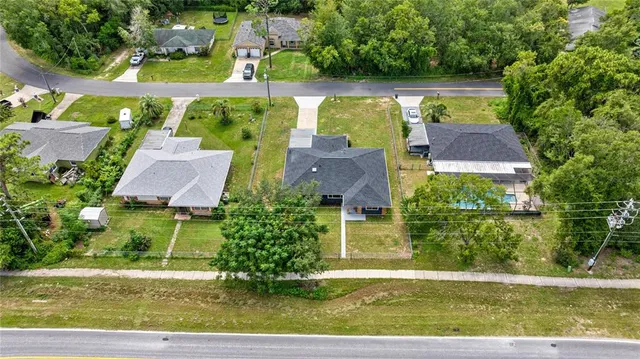 an aerial view of a house with swimming pool and green space
