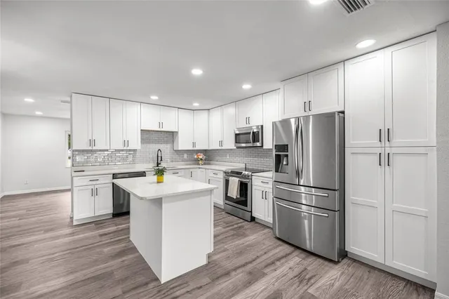 a kitchen with white cabinets and stainless steel appliances