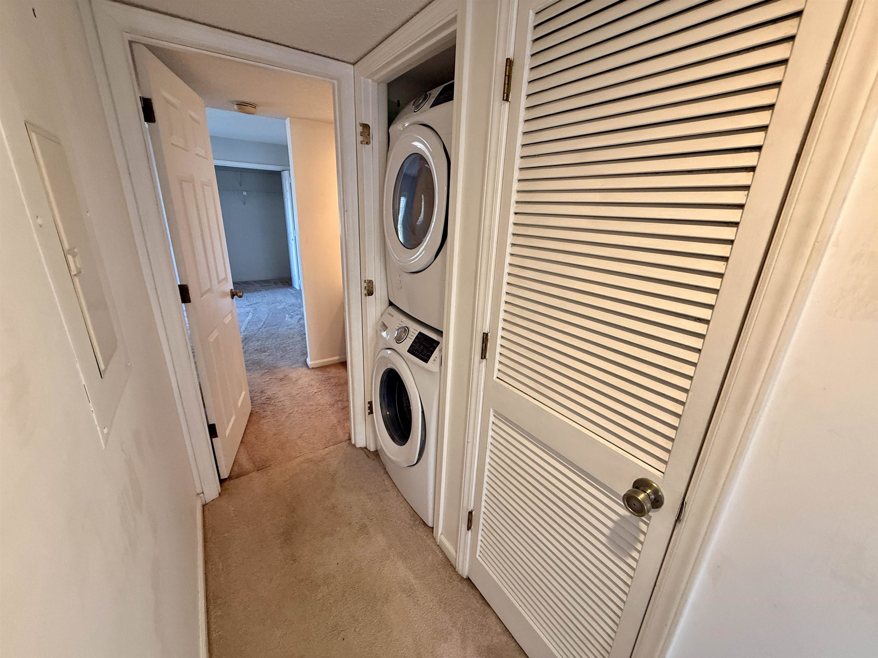 4230 Pinehurst Circle, Unit K4 Little River, SC 29566 - Photo 13 of 25 Laundry area featuring light carpet, stacked washing machine and dryer, and electric panel