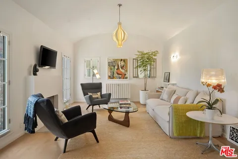 a living room with furniture a window and a flat screen tv