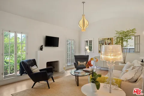 a living room with furniture a flat screen tv and a large window