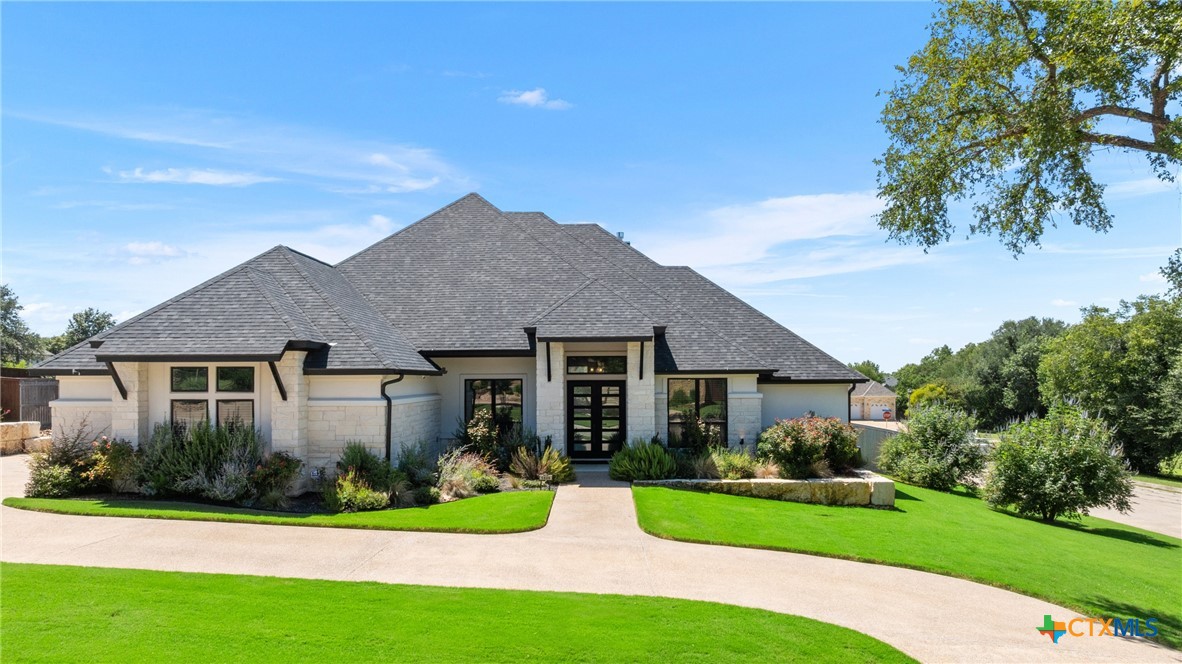 a front view of a house with a yard and potted plants