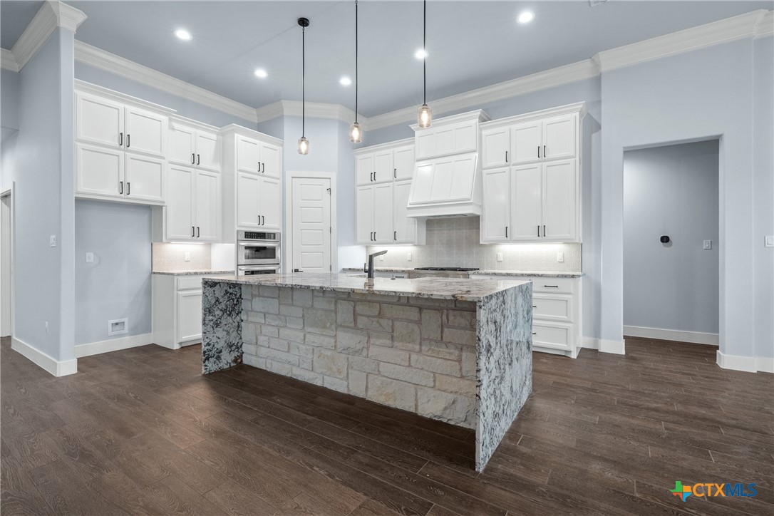1606 Alta Vista Loop Temple, TX 76502 - Photo 14 of 48 a large kitchen with kitchen island a stove a sink a refrigerator white cabinets and wooden floor