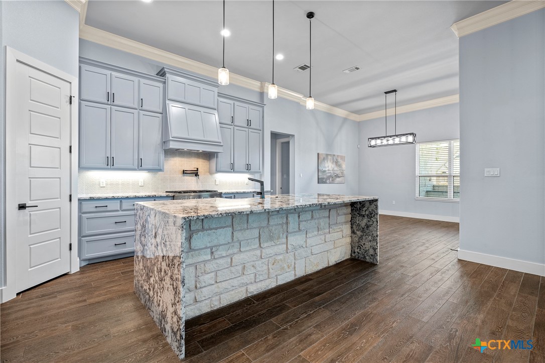 1606 Alta Vista Loop Temple, TX 76502 - Photo 15 of 48 a kitchen with stainless steel appliances kitchen island wooden floors cabinets and a window