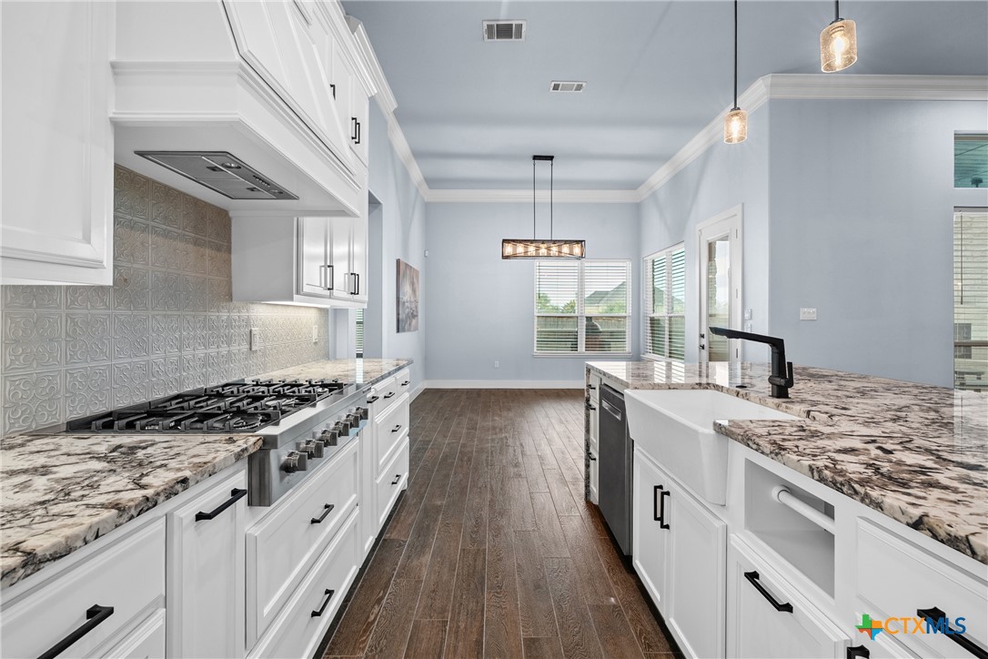 1606 Alta Vista Loop Temple, TX 76502 - Photo 17 of 48 a kitchen with granite countertop a sink stove and cabinets