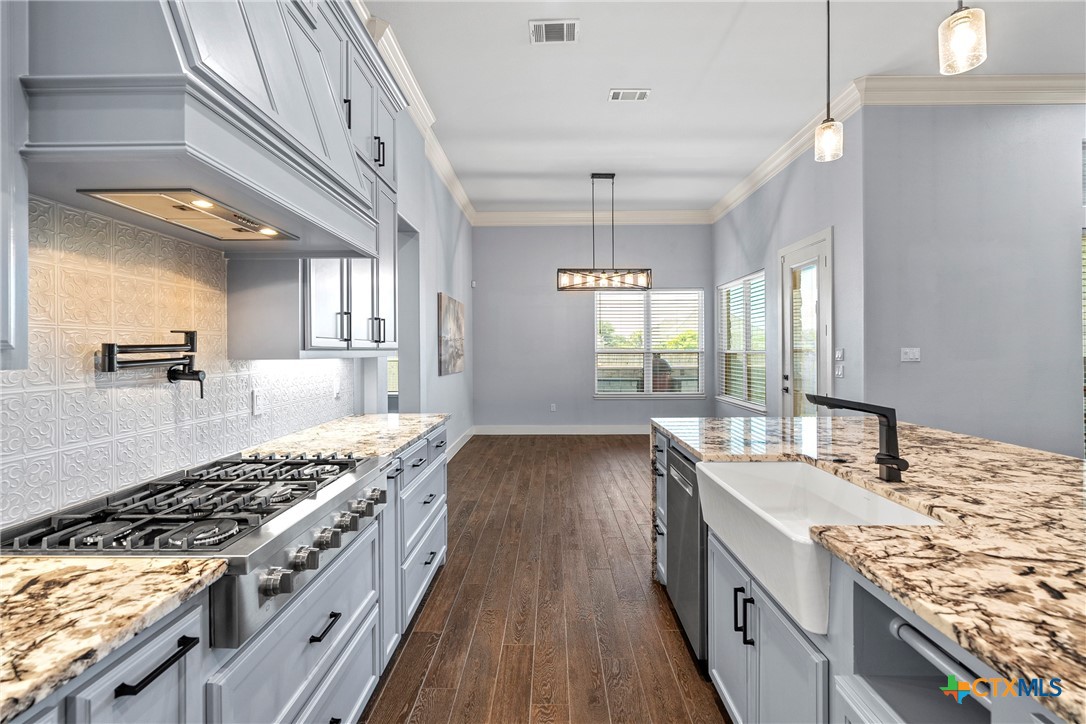 1606 Alta Vista Loop Temple, TX 76502 - Photo 18 of 48 a kitchen with a stove a sink a refrigerator and wooden floor