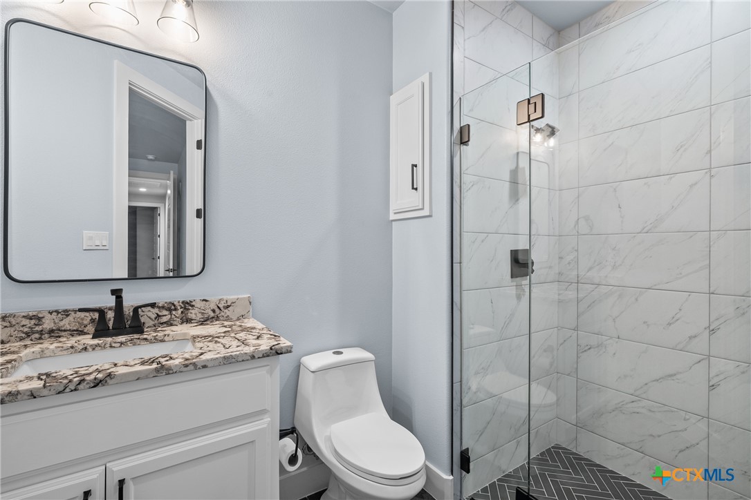 1606 Alta Vista Loop Temple, TX 76502 - Photo 27 of 48 a bathroom with a granite countertop toilet sink shower and mirror
