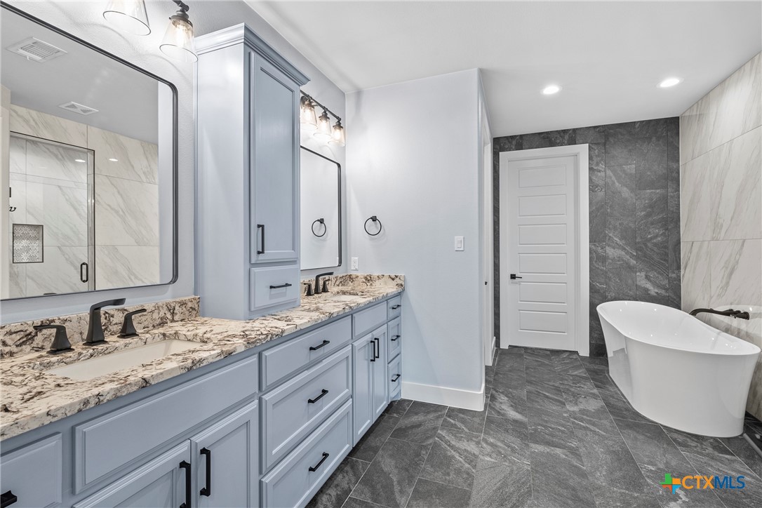 1606 Alta Vista Loop Temple, TX 76502 - Photo 3 of 48 a spacious bathroom with a double vanity sink mirror and bathtub