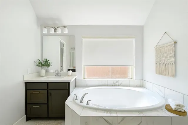 a bathroom with a tub sink and a mirror