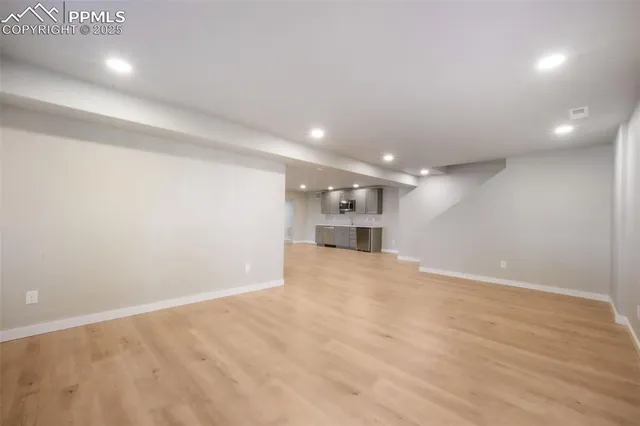 an empty room with wooden floor and fireplace
