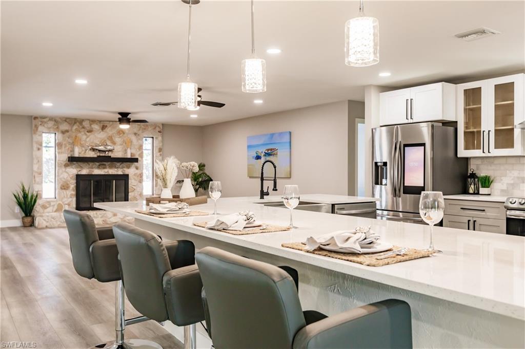 362 Pinehurst Circle Naples, FL 34113 - Photo 13 of 50 a kitchen with stainless steel appliances kitchen island granite countertop a dining table and chairs