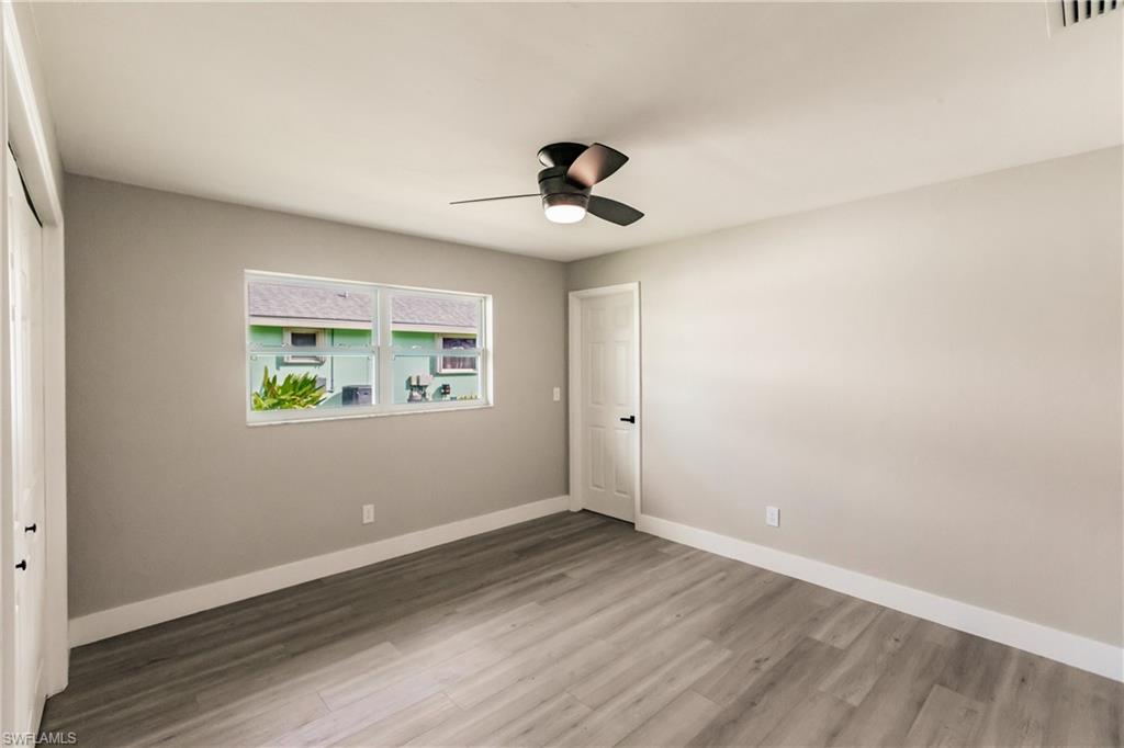 362 Pinehurst Circle Naples, FL 34113 - Photo 30 of 50 an empty room with wooden floor ceiling fan and windows