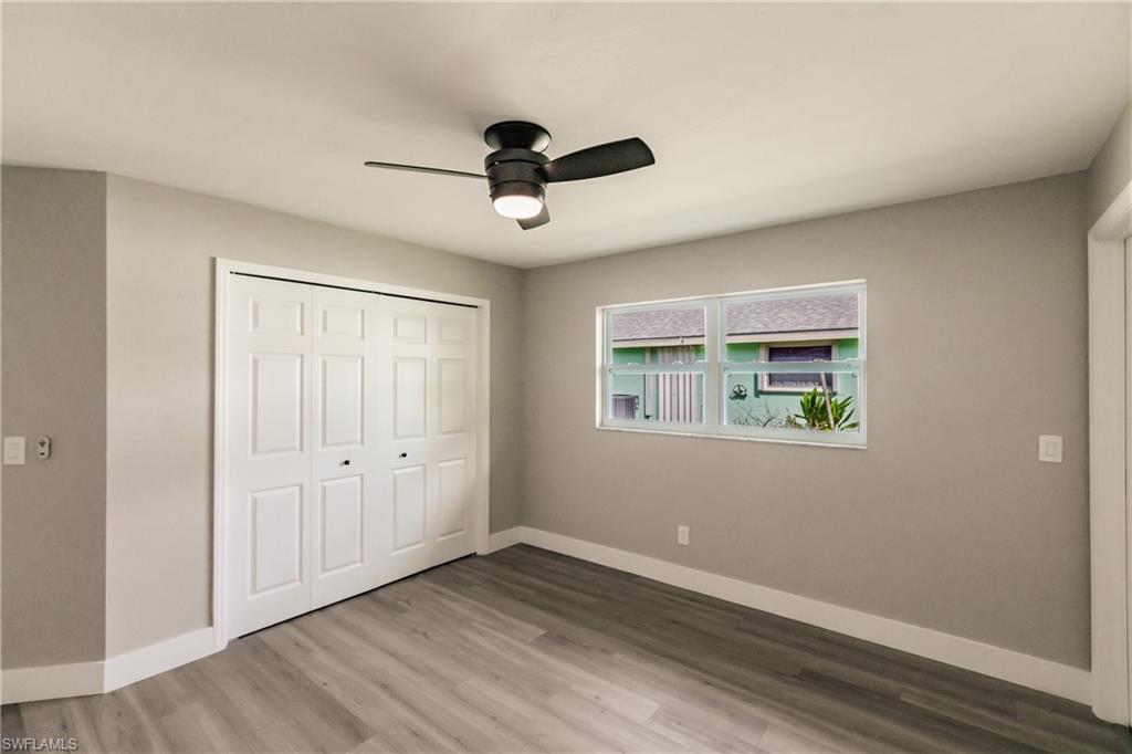 362 Pinehurst Circle Naples, FL 34113 - Photo 31 of 50 an empty room with wooden floor ceiling fan and windows