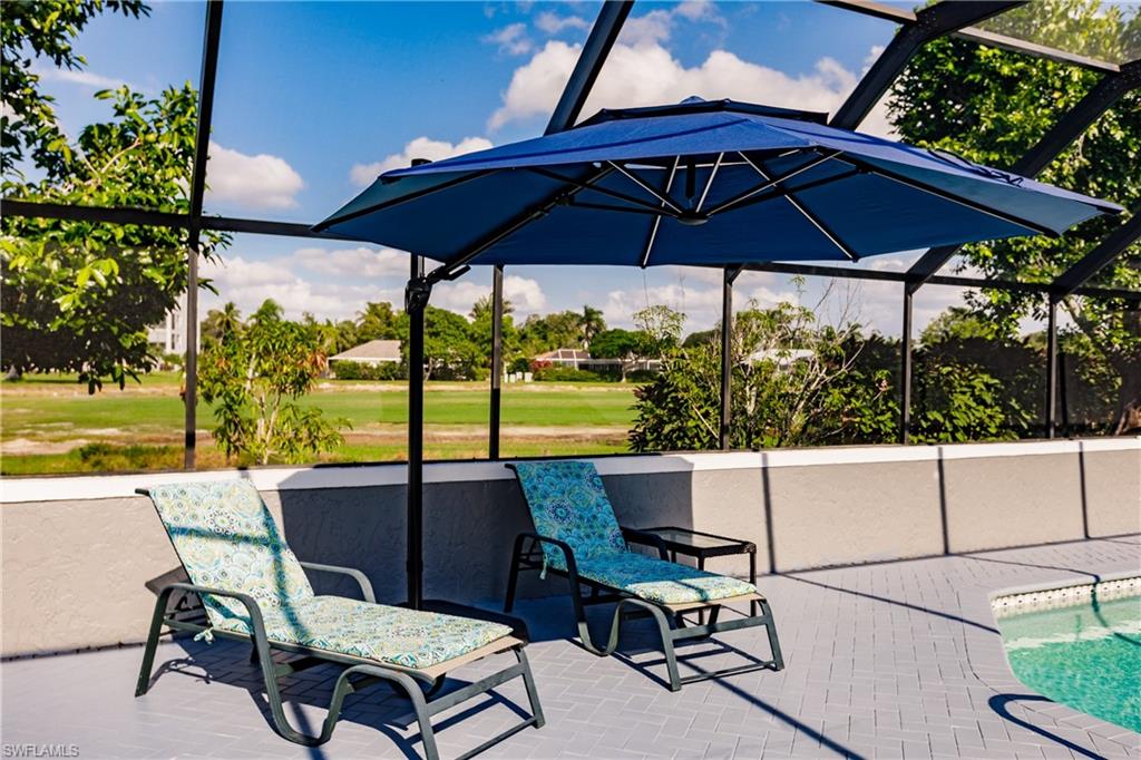 362 Pinehurst Circle Naples, FL 34113 - Photo 40 of 50 a view of patio with chairs under an umbrella
