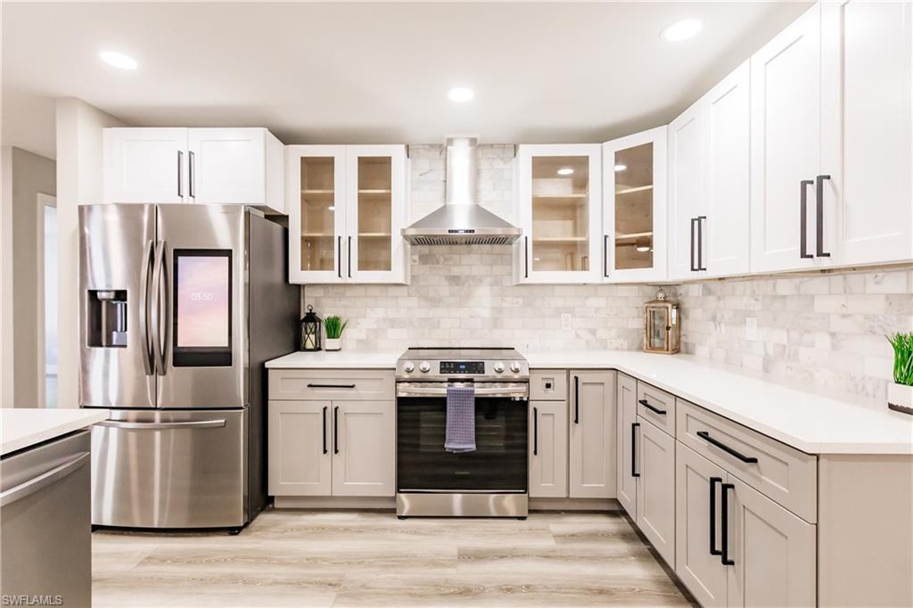 362 Pinehurst Circle Naples, FL 34113 - Photo 10 of 50 a kitchen with stainless steel appliances granite countertop a stove and a refrigerator