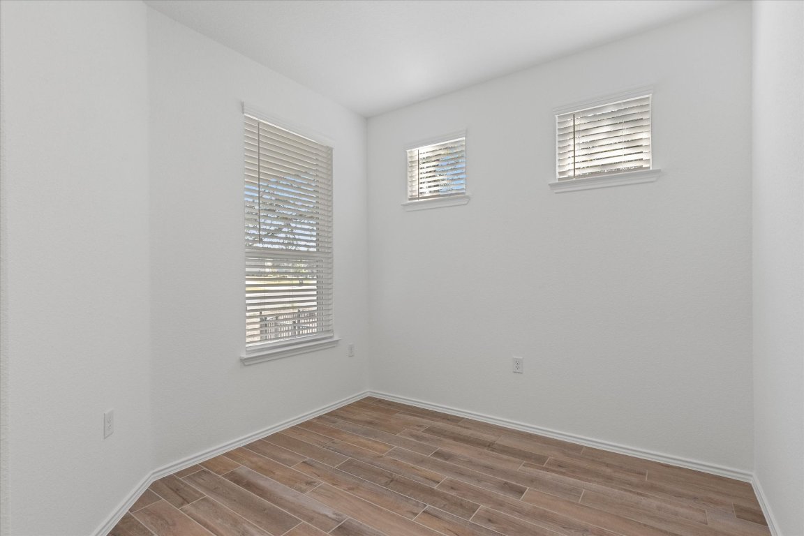 324 Livewater Lane Georgetown, TX 78633 - Photo 6 of 31 a view of an empty room with wooden floor and a window