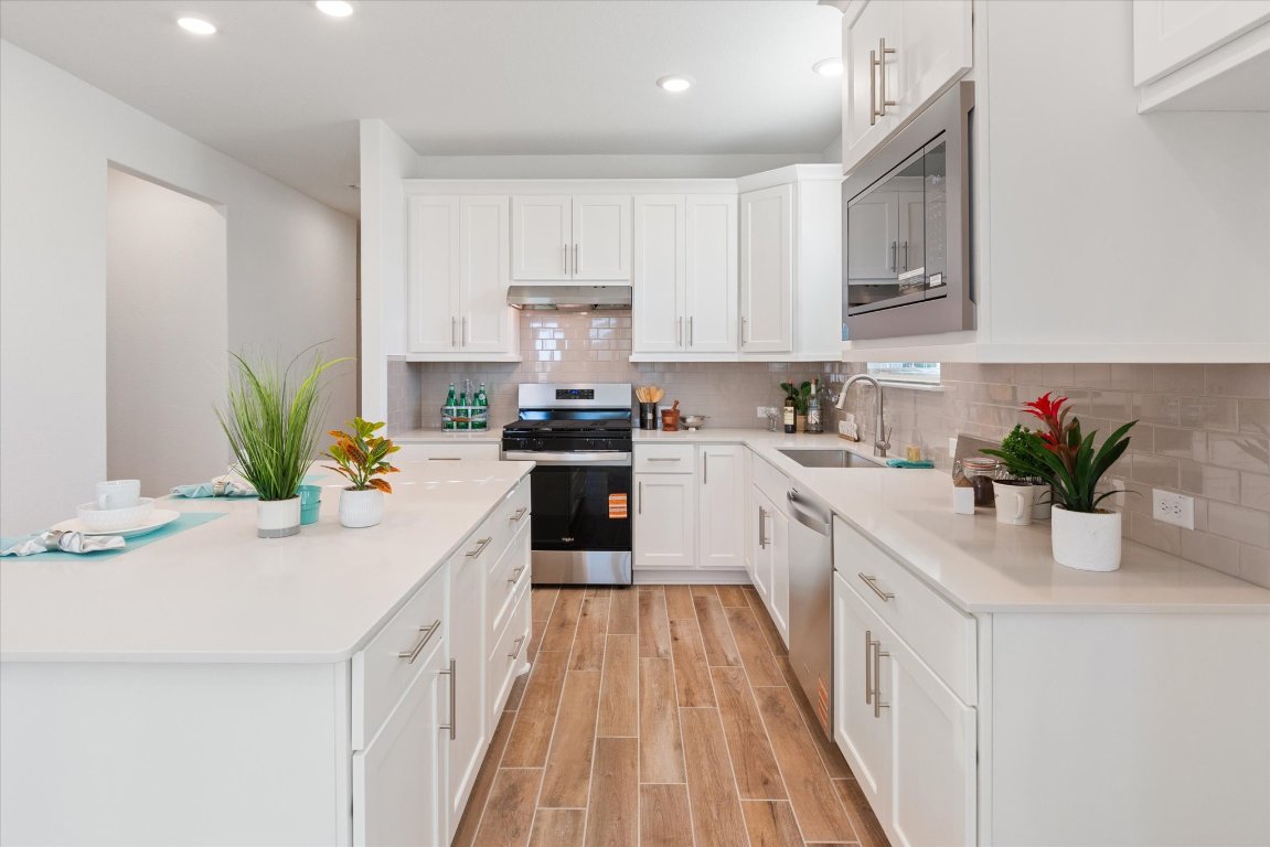324 Livewater Lane Georgetown, TX 78633 - Photo 10 of 31 a kitchen with stainless steel appliances a sink a counter top space cabinets and a potted plant