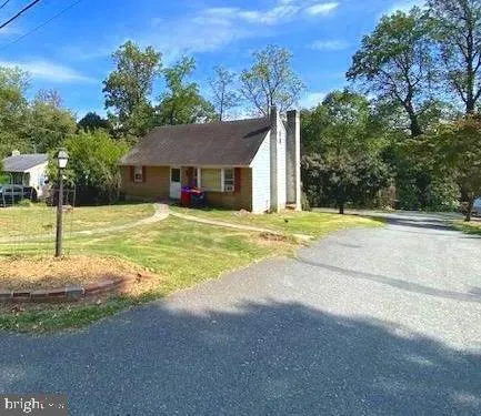 a view of a house with a big yard and large trees