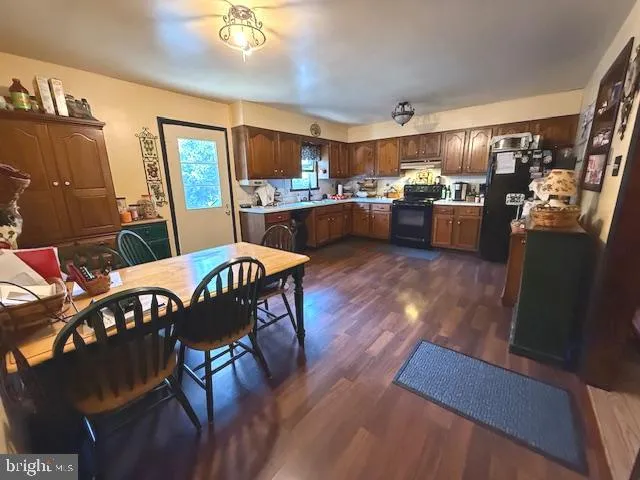 a open kitchen view with stainless steel appliances furniture stove and wooden floor