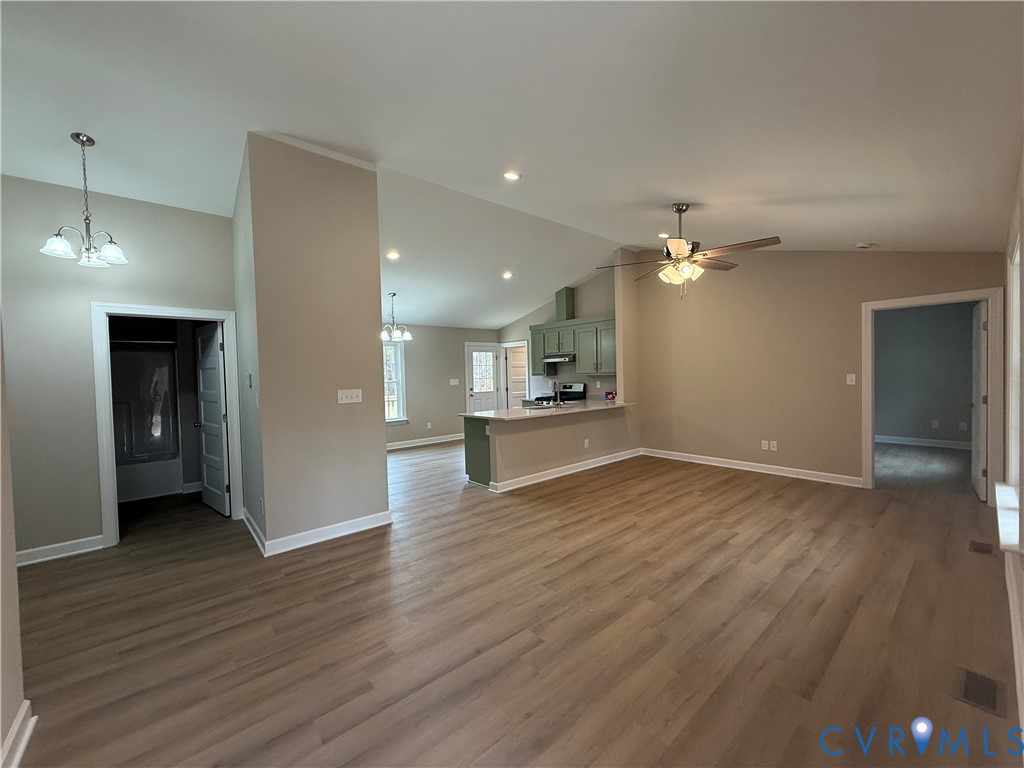 342 Barefords Mill Road Dunnsville, VA 22454 - Photo 4 of 15 a view of an empty room with wooden floor and a kitchen