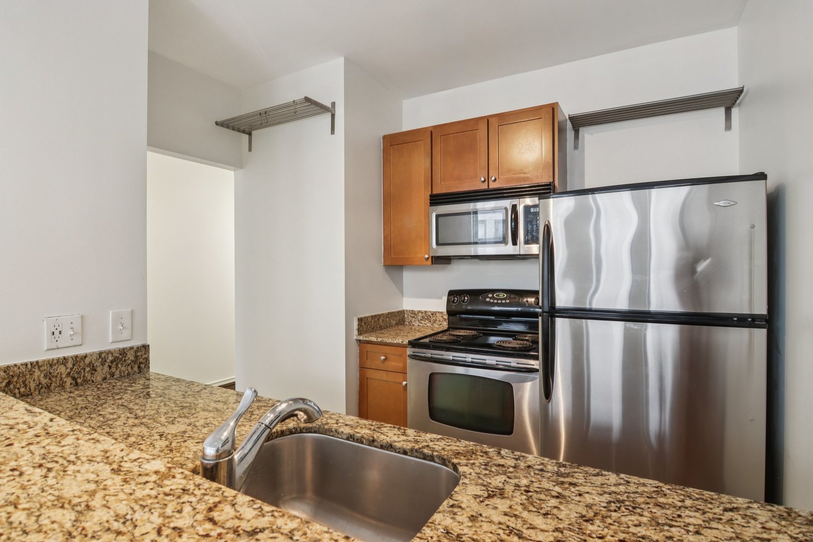 780 South Federal Street, Unit 902 Chicago, IL 60605 - Photo 17 of 28 a kitchen with granite countertop a refrigerator stove and microwave