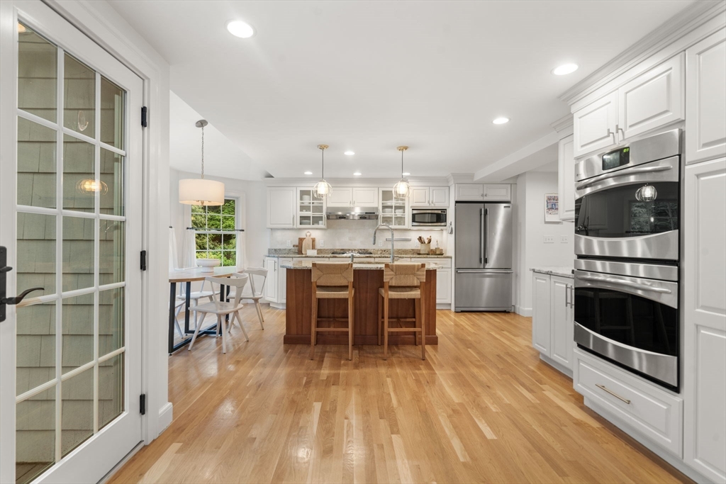9 Lafayette Circle Wellesley, MA 02482 - Photo 13 of 35 a kitchen with stainless steel appliances a stove a refrigerator a microwave oven with white cabinets and wooden floor