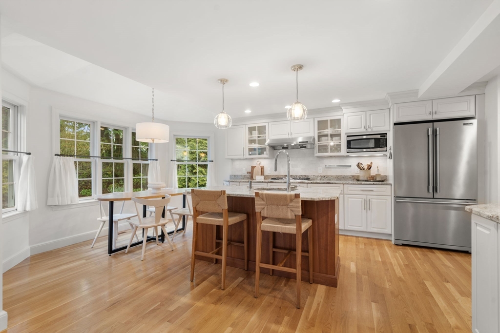 9 Lafayette Circle Wellesley, MA 02482 - Photo 14 of 35 a kitchen with a table chairs refrigerator and cabinets