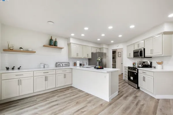 a kitchen with cabinets stainless steel appliances and a counter space