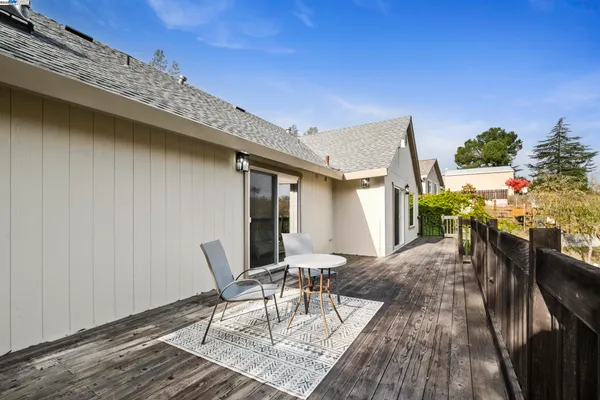 a view of a balcony with wooden floor and fence