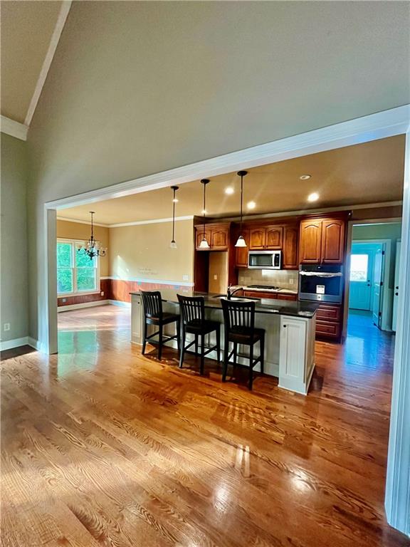 348 Hidden Trail Pendergrass, GA 30567 - Photo 13 of 40 a kitchen with stainless steel appliances kitchen island granite countertop a refrigerator a stove and a dining table with wooden floor